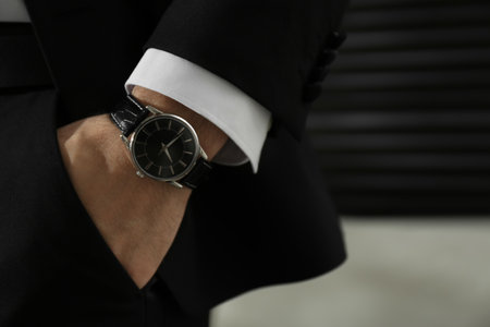 Businessman with luxury wrist watch on blurred background, closeupの写真素材