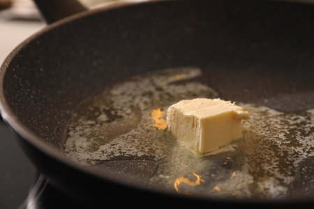 Frying pan with melted butter on stove, closeupの写真素材