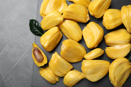 Delicious exotic jackfruit bulbs on gray table, top view