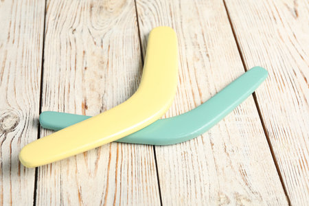 Color boomerangs on white wooden background. outdoor activityの写真素材