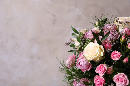 Beautiful bouquet with roses on beige background, closeup. Space for textの写真素材