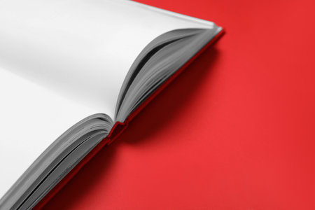 Open book on red background, closeup. Space for textの写真素材
