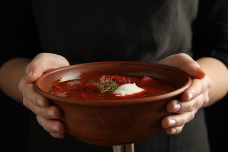 Woman holding clay bowl with Ukrainian borsch, closeupの写真素材