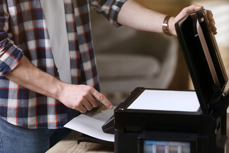 Man using modern multifunction printer in office, closeupの写真素材