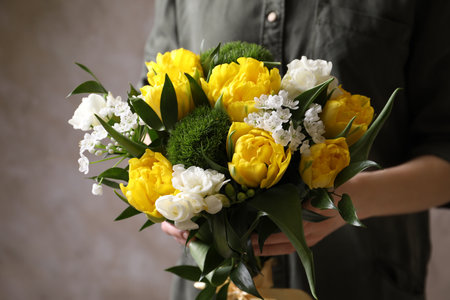 Woman with bouquet of beautiful peony tulips on beige background, closeupの写真素材
