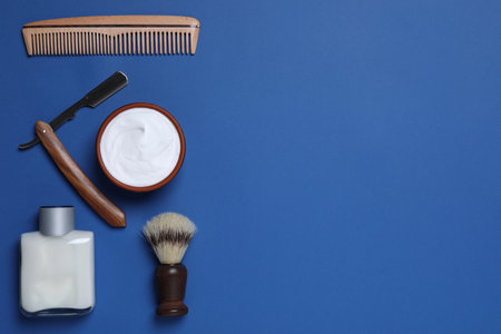 Flat lay composition with men's shaving accessories on blue background, space for textの写真素材