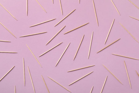 Wooden toothpicks on pink background, flat layの写真素材