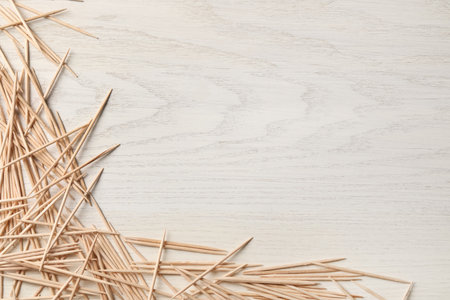 Disposable toothpicks on white wooden background, flat lay. Space for textの写真素材