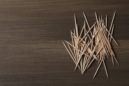 Disposable toothpicks on wooden background, flat lay. Space for textの写真素材