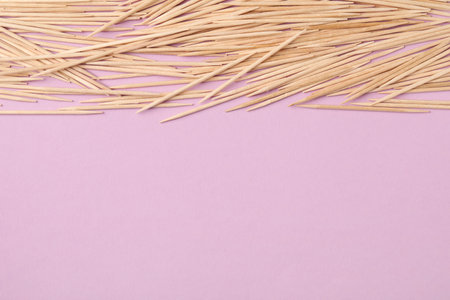 Wooden toothpicks on pink background, flat lay. Space for textの写真素材