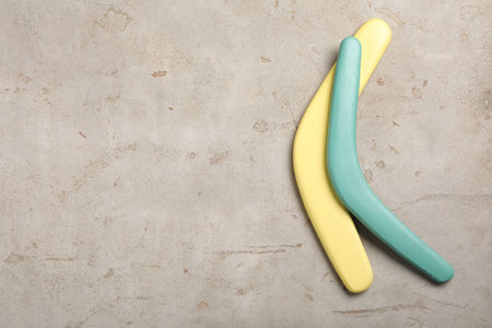 Boomerangs on light gray stone background, flat lay. Space for textの写真素材