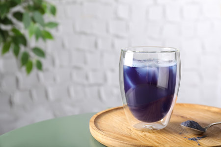 Delicious blue matcha tea with ice cubes on table, space for textの写真素材