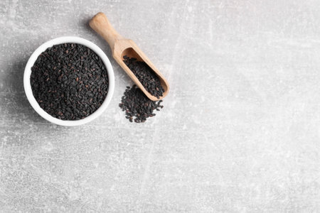 Black sesame seeds on gray table, flat lay. Space for textの写真素材