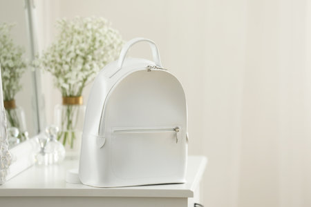 Stylish white backpack on table indoors, space for textの写真素材