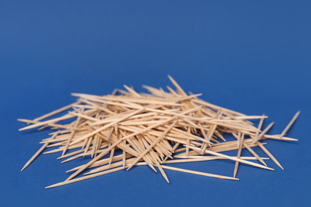 Pile of wooden toothpicks on blue backgroundの写真素材