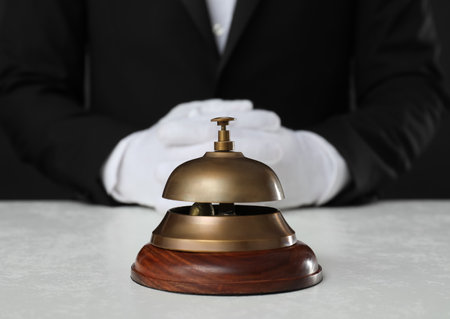 Butler at white desk with service bell, closeup viewの写真素材