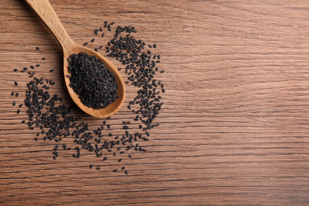Black sesame seeds on wooden table, flat lay. Space for textの写真素材