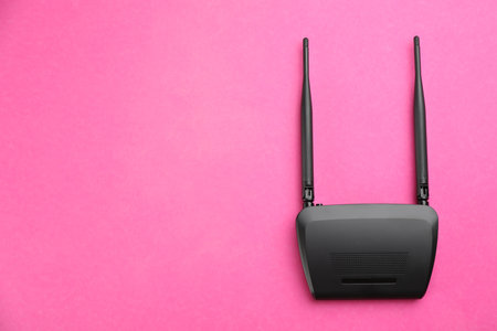 Modern WiFi router on pink background, top view. Space for textの写真素材