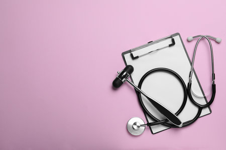 Reflex hammer, stethoscope and clipboard on pink background, flat lay with space for text. Nervous system diagnosticの写真素材