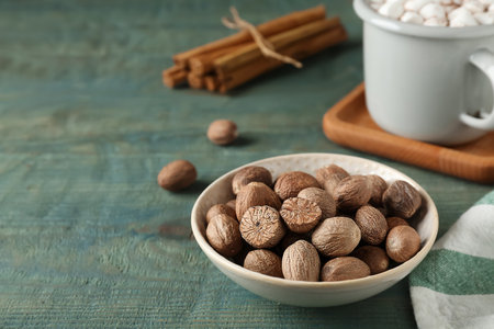 Nutmegs in bowl on blue wooden table. Space for textの写真素材