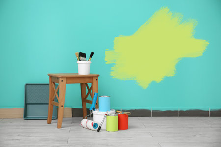 Set with decorator's tools and paint on floor near turquoise wallの写真素材
