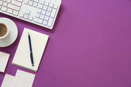 Modern keyboard with RGB lighting and stationery on purple background, flat lay. Space for textの写真素材