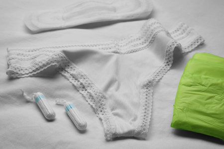 Woman's panties, menstrual pads and tampons on white fabricの写真素材