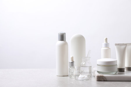 Organic cosmetic products and laboratory glassware on white table, space for textの写真素材