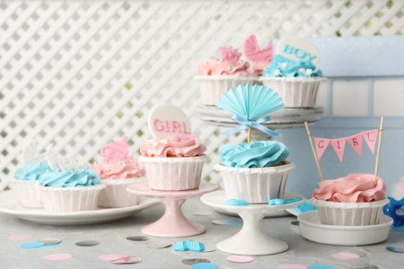Delicious cupcakes with light blue and pink cream for baby shower on gray tableの写真素材