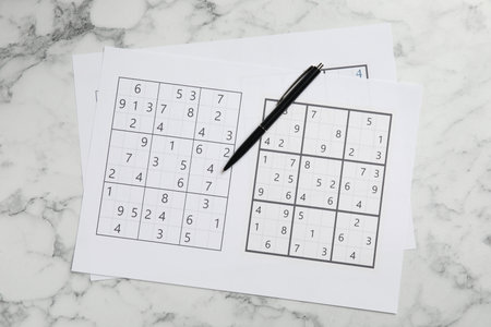 Sudoku and pen on white marble table, top viewの写真素材