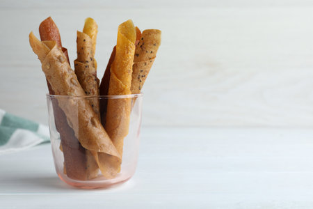 Delicious fruit leather rolls on white wooden table. Space for textの写真素材