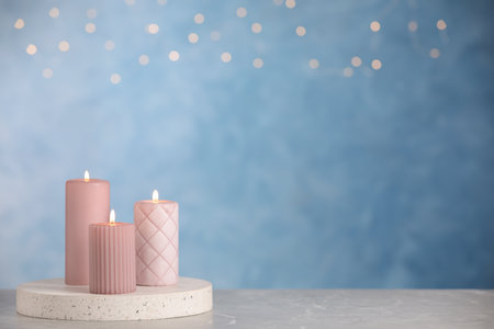 Burning candles on light gray marble table. space for textの写真素材