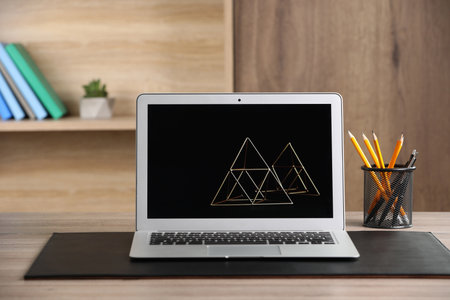 Modern laptop and office supplies on wooden table indoorsの写真素材