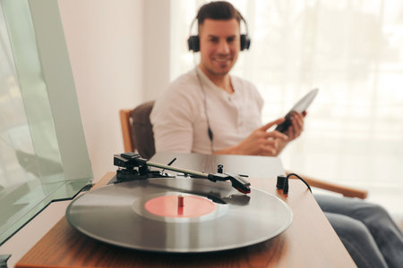 Man listening to music at home, focus on turntable with vinyl recordの写真素材