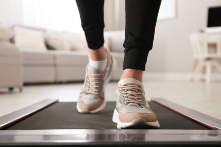 Woman training on walking treadmill at home, closeupの写真素材