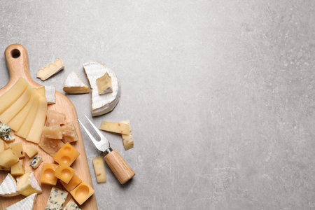 Cheese plate and cutlery on gray table, flat lay. Space for textの写真素材