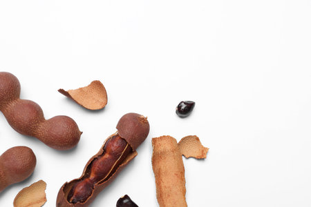 Ripe tamarinds on white background, flat lay. Space for textの写真素材