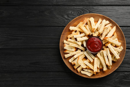 Delicious hard chucks with ketchup on black wooden table, top view. Space for textの写真素材