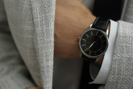 Businessman in jacket with luxury wrist watch, closeup