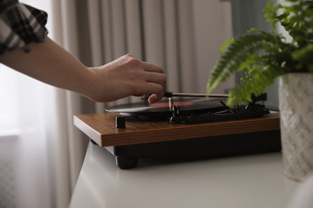 Young woman using turntable at home, closeupの写真素材
