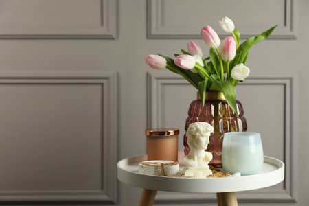 Beautiful David bust candle, flowers and decor on white table. Space for textの写真素材