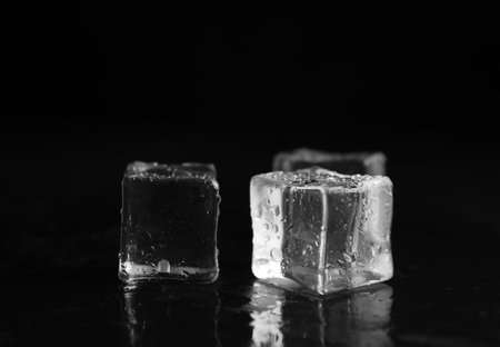 Ice cubes with water drops on black background, closeupの写真素材