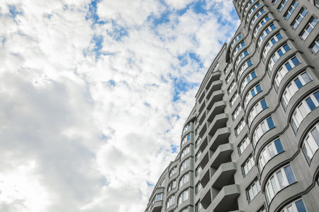 Modern building under cloudy sky, low angle viewの写真素材