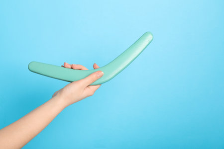 Woman holding boomerang on light blue background, closeup. Space for textの写真素材
