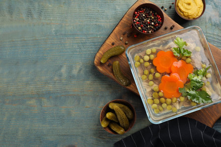 Delicious aspic and ingredients served on light blue wooden table, flat lay. Space for textの写真素材