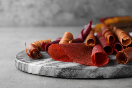 Delicious fruit leather rolls on gray table, closeupの写真素材