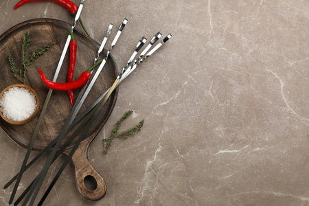 Flat lay composition with metal skewers on gray marble table. Space for textの写真素材