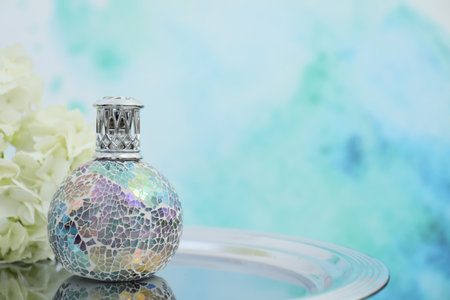 Stylish catalytic lamp with hydrangea on tray against light blue background, space for text. element of interiorの写真素材