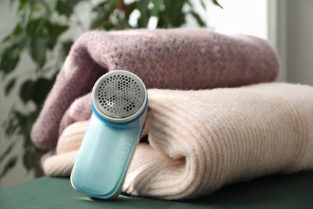 Modern fabric shaver and woolen sweaters indoors, closeupの写真素材