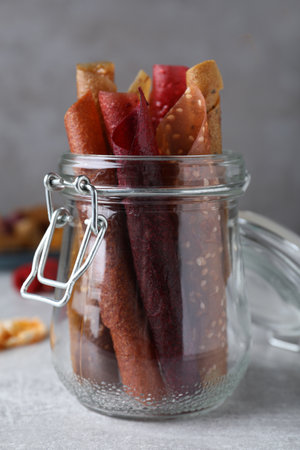 Delicious fruit leather rolls on gray tableの写真素材